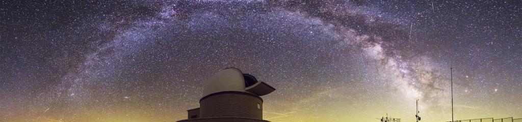 imagen de noche con el edificio del observatorio del Montsec y las estrellas a la vía lactea
